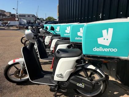 A row of Otto electric mopeds with Deliveroo delivery boxes