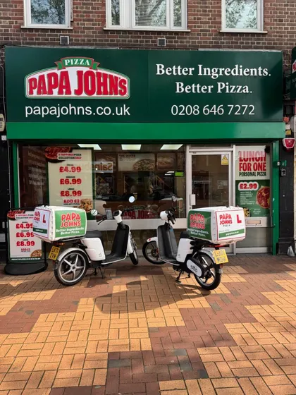Two Papa Johns-liveried Otto mopeds outside a Papa Johns branch